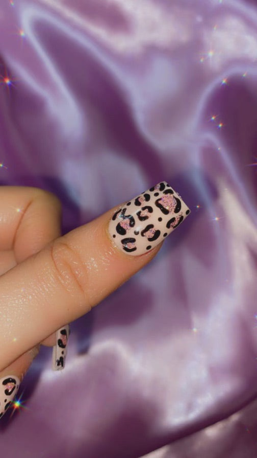 Elegant leopard print press-on nails on a soft, ethereal purple background.