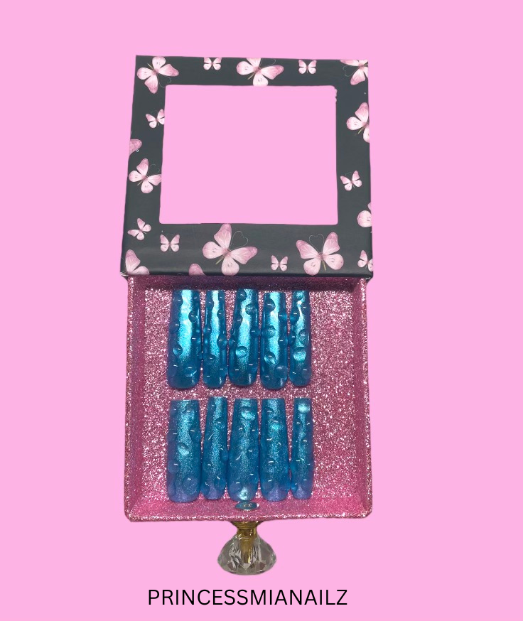 Glittering teal press-on nails in a stylish butterfly-framed display, ready to transform your nails into a royal statement from PrincessMiaNailz.